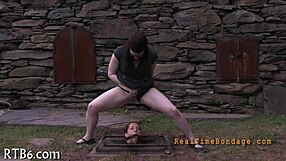 bound woman endures sadomasochism bondage session in dark room