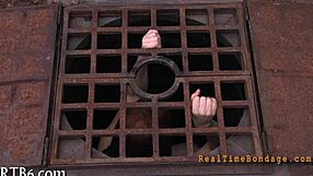 bound woman endures sadomasochism bondage session in dark room