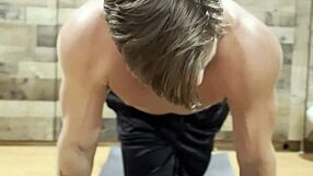 muscular bodybuilder stretches intensely in the gym