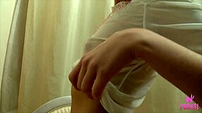 Evie sitzt auf Stuhl, spreizt engen Arsch weit. Sie teaset rasierte Muschilippen mit langsamen, gewagten Bewegungen.