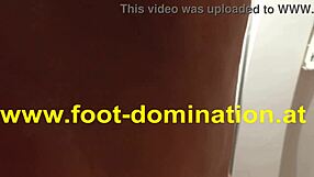 The redhead dominatrix stomps on her slave's feet, licking and sucking toes in a bdsm session.