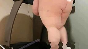 Obese woman exercises on treadmill and smoothes out her large bust and hips