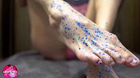 cute girl passionately plays with glitters and gives footjob to big dildo