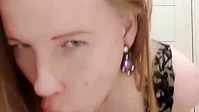 Milf sucks dildo while caressing wet pussy in restroom