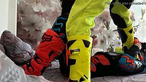 Motocross biker in costumes treads with boots suggestively