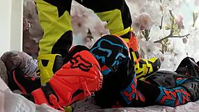 Motocross biker in costumes treads with boots suggestively