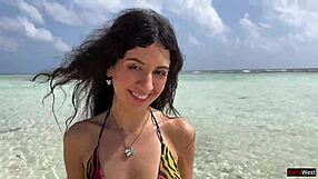 Kráska MOČÍ na pláži na Maledivách se zlatou sprchou