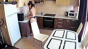 Beautiful big-breasted woman works in the kitchen without her top on