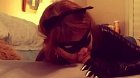 A mature woman in cosplay of Catwoman gives a deep blow job to Batman