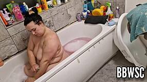 A pervert watches a busty BBW wash her big boobs in the bathtub