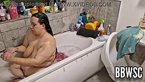 A pervert watches a busty BBW wash her big boobs in the bathtub