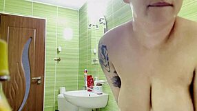 Tattooed woman with big tits and ass masturbates in the shower alone