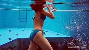 Martina wears a blue bikini in the underwater shower at the beach