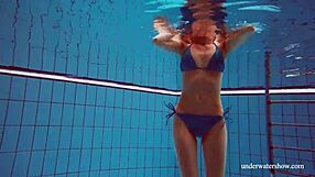 Martina wears a blue bikini in the underwater shower at the beach