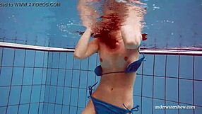 Martina wears a blue bikini in the underwater shower at the beach
