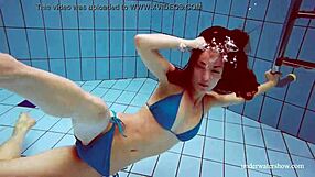 Martina wears a blue bikini in the underwater shower at the beach