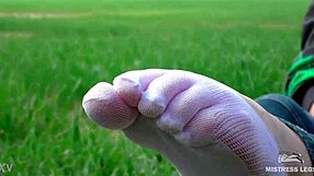 goddess feet in cute white socks with jeans on the spring grass field