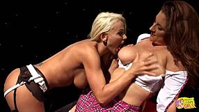 This Brunette Girl With Huge Breasts Was Drilled By A Blonde Lesbian With A Strapon