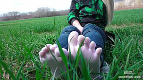 goddess feet in cute white socks with jeans on the spring grass field