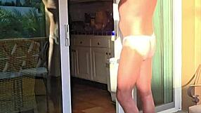 Pervy guy stretches in thongs on balcony vacation