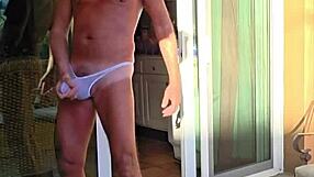 Pervy guy stretches in thongs on balcony vacation