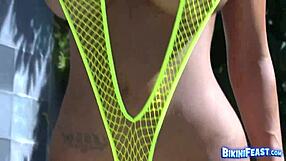 Stunning babe poses seductively in net bikini, revealing tits and pussy lips.