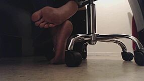 El chico de los pies mira suelas sucias bajo el escritorio