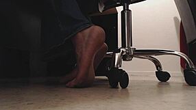 Foot boy watches dirty soles under desk