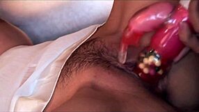 Two Asian lesbians in white lingerie use strapon and fingers for intense pussy play