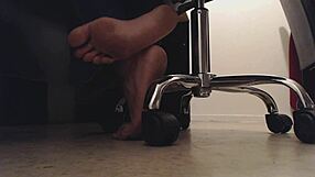 Foot boy watches dirty soles under desk