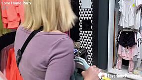 Girlfriend kneels in changing booth for blowjob.