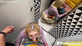 Girlfriend kneels in changing booth for blowjob.