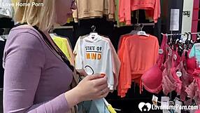 Girlfriend kneels in changing booth for blowjob.