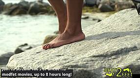 Giggles rubs feet on giant hot rock at beach
