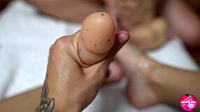 Two cuties with shiny legs boldly play with huge rubber cock in footjob action