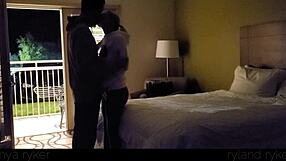 Young couple enjoys intimate time in motel with door open