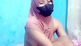 Hijab-clad Indonesian girl masturbates to orgasm with dildo.